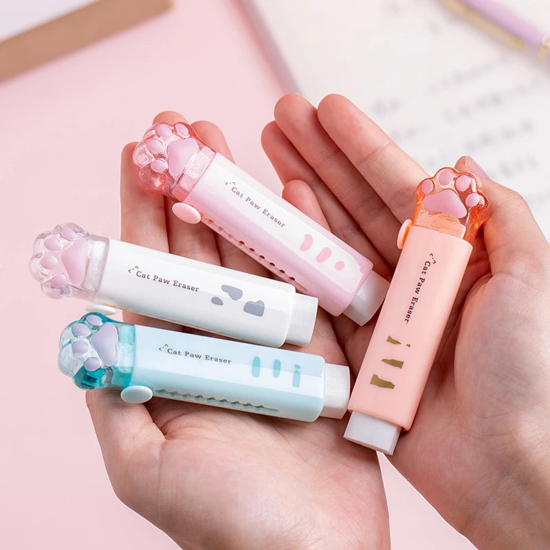 Cat paw retractable pencil erasers in pink, white, light blue, and orange, held in hands
