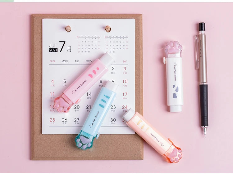 Retractable cat paw pencil eraser with pastel blue and orange colors beside calendar