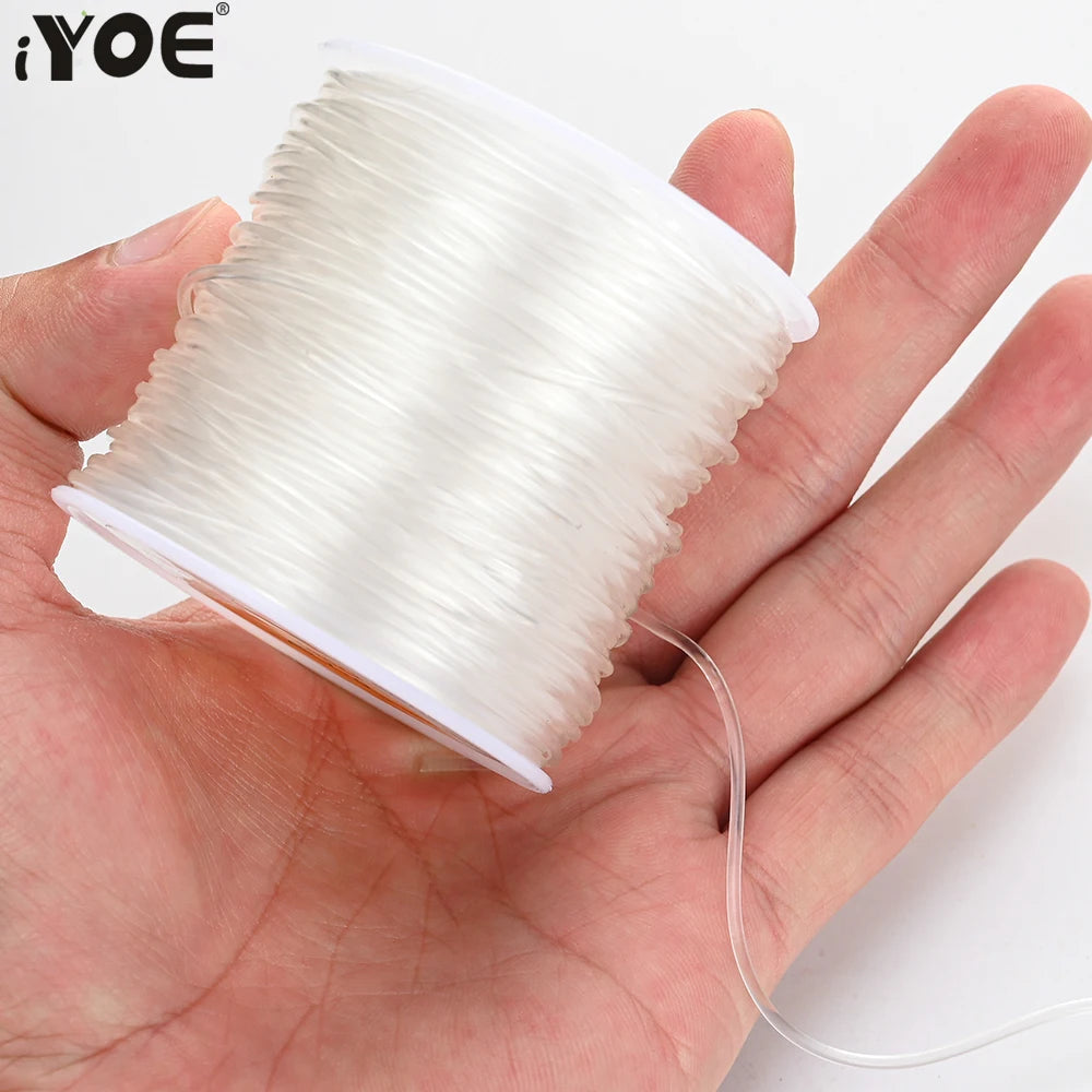 Transparent elastic cord on a spool, white thread held in open hand