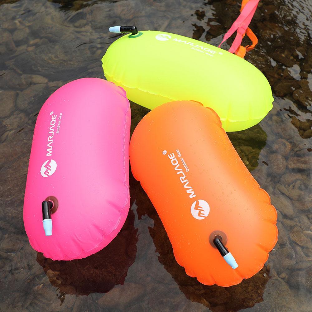 Inflatable swim buoy tow float set, pink, orange, and neon green floats on water