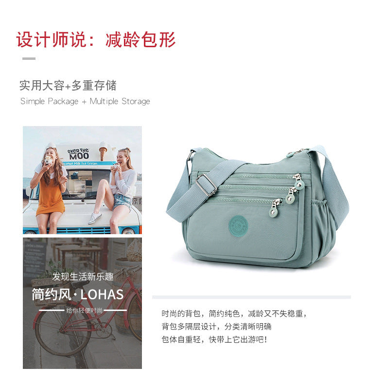 Lightweight multi-layer nylon shoulder bag, water-blue hobo-style shape with front zip pocket.