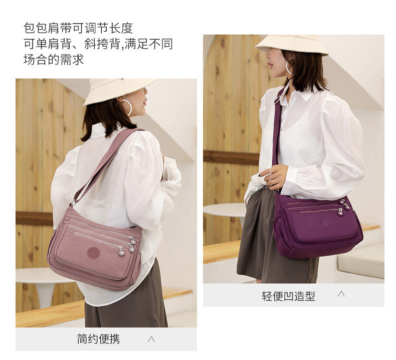 Lightweight multi-layer nylon shoulder bag, purple crossbody with adjustable strap.