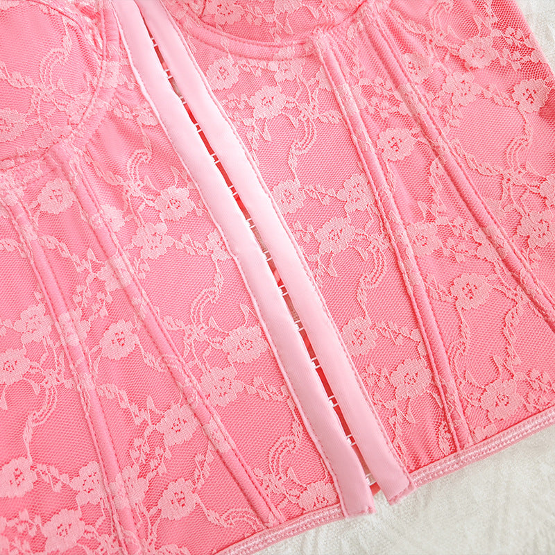 Pink lace corset vest with crisscross straps and boning details