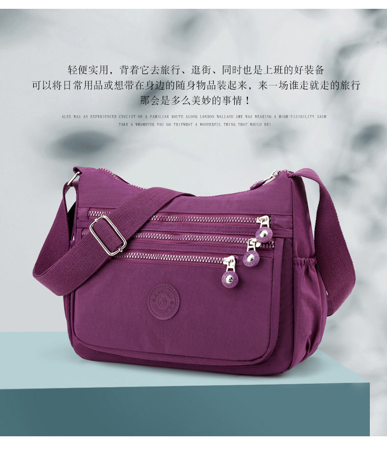 Lightweight multi-layer nylon shoulder bag, purple crossbody with front double zippers.
