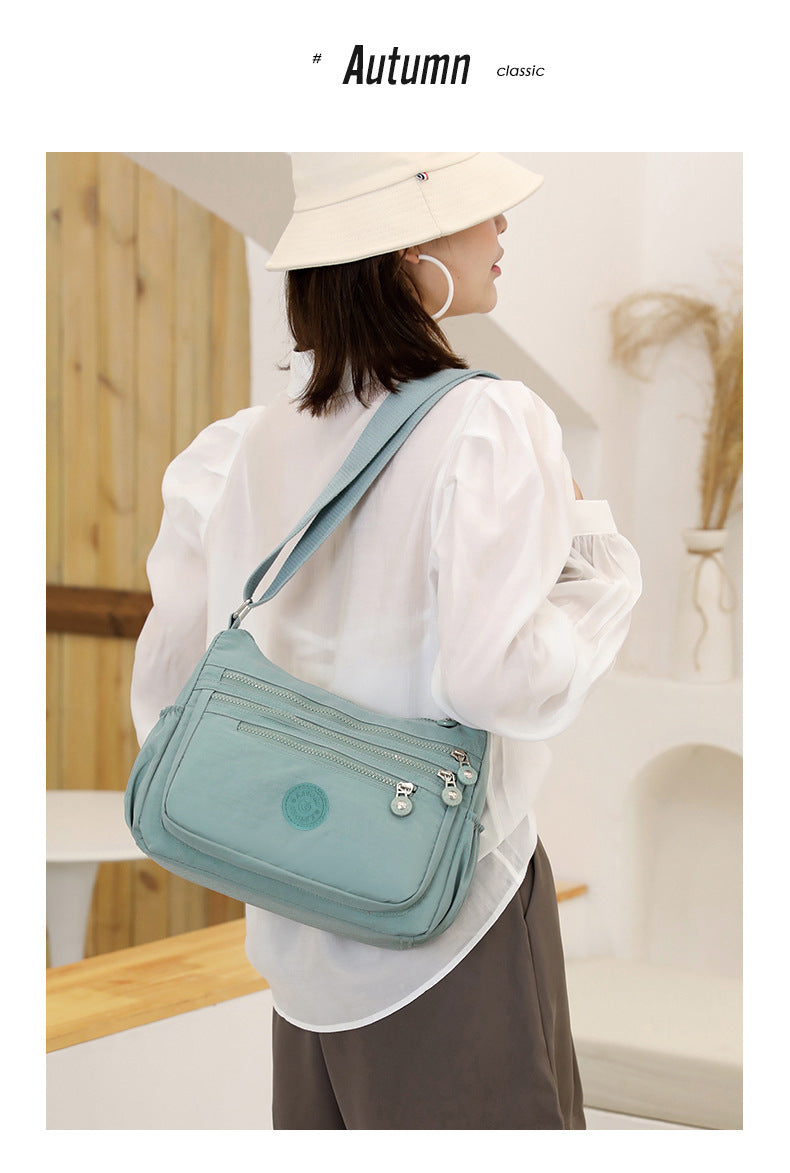 Nylon multi-layer crossbody shoulder bag, light water-blue, side profile with front flap