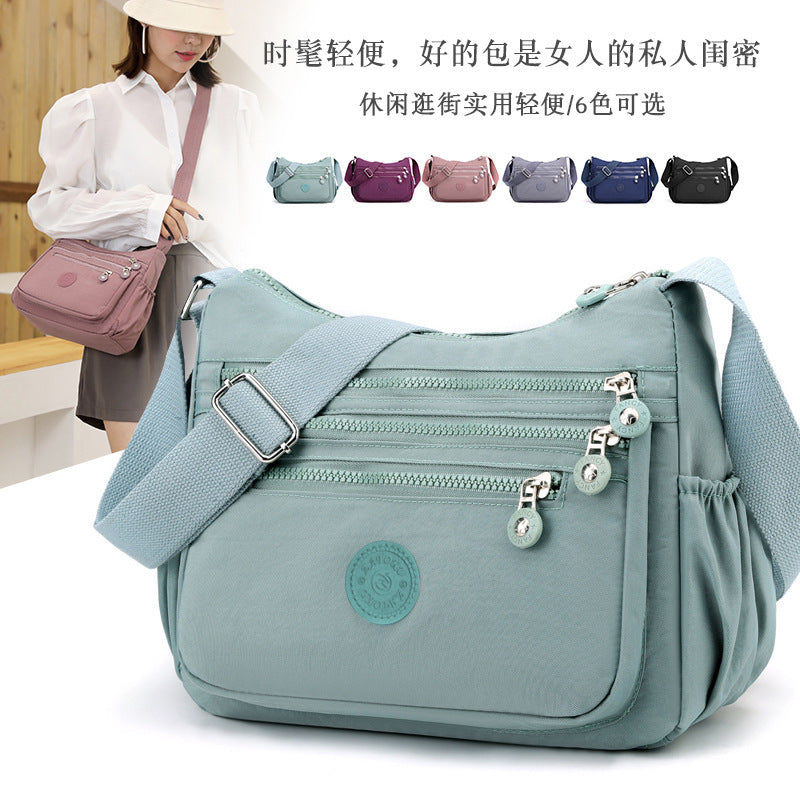 Nylon multi-layer crossbody bag, light teal blue, adjustable strap and zip pockets