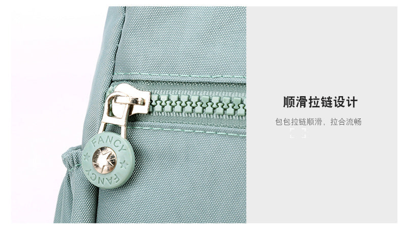 Light blue nylon bag zipper track with stitched trim and round zipper pull charm