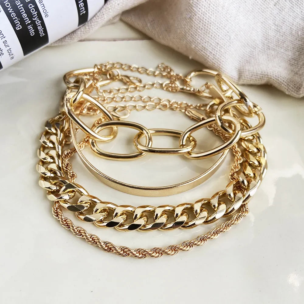 Gold-tone chain bracelet set with thick curb links and open bangle cuffs