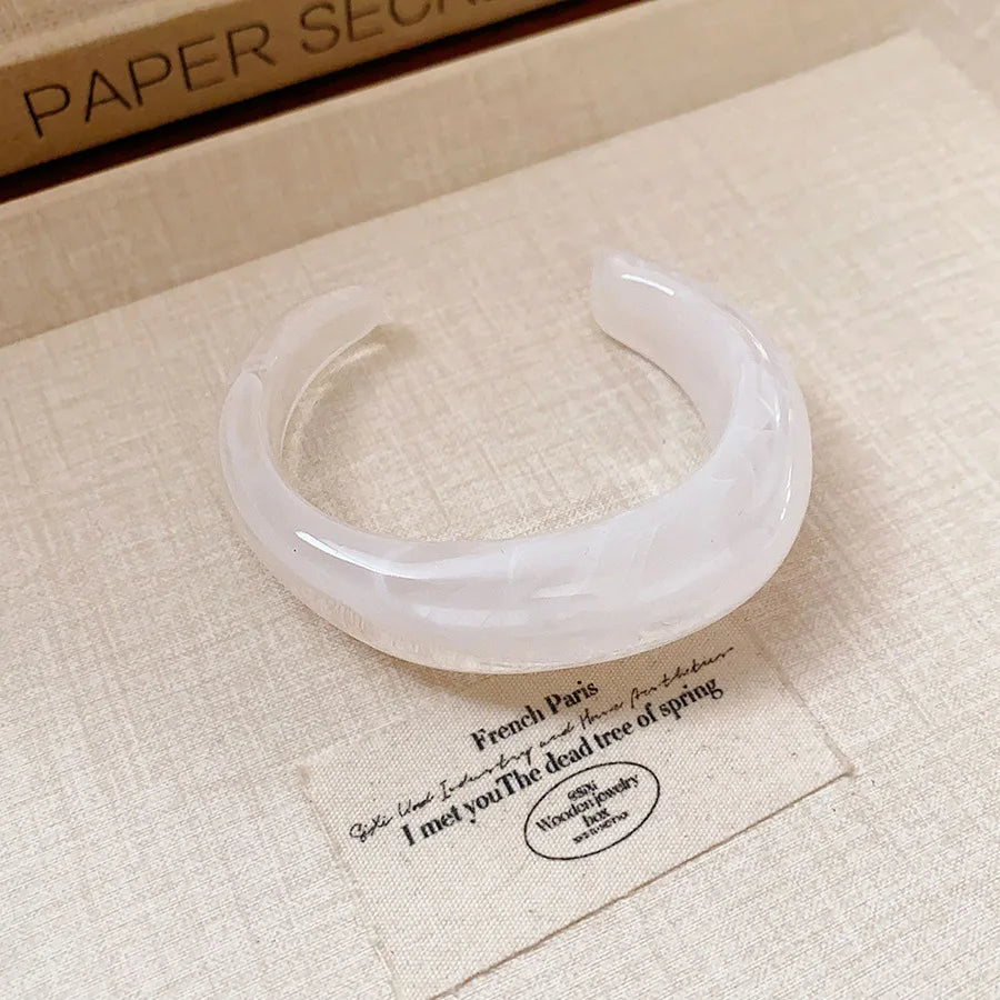 Shiny acrylic open bangle in translucent white, wide curved minimalist bracelet