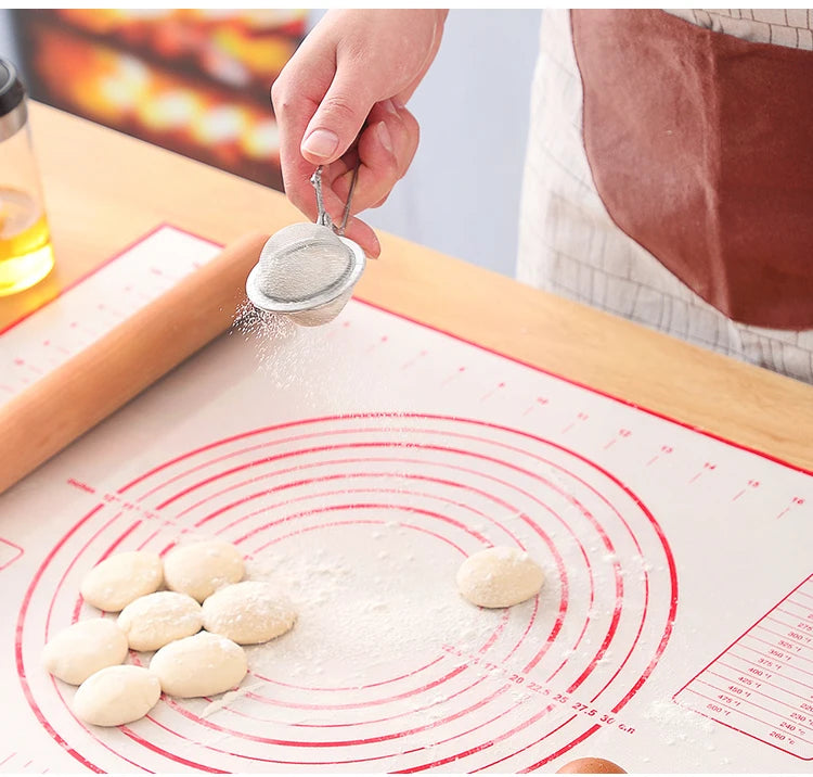 Silicone baking mat with red circular guides, flour dusting dough on mat