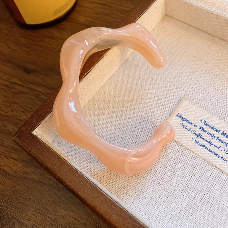 Soft pink translucent acrylic open bangle with shiny rounded face smudge design
