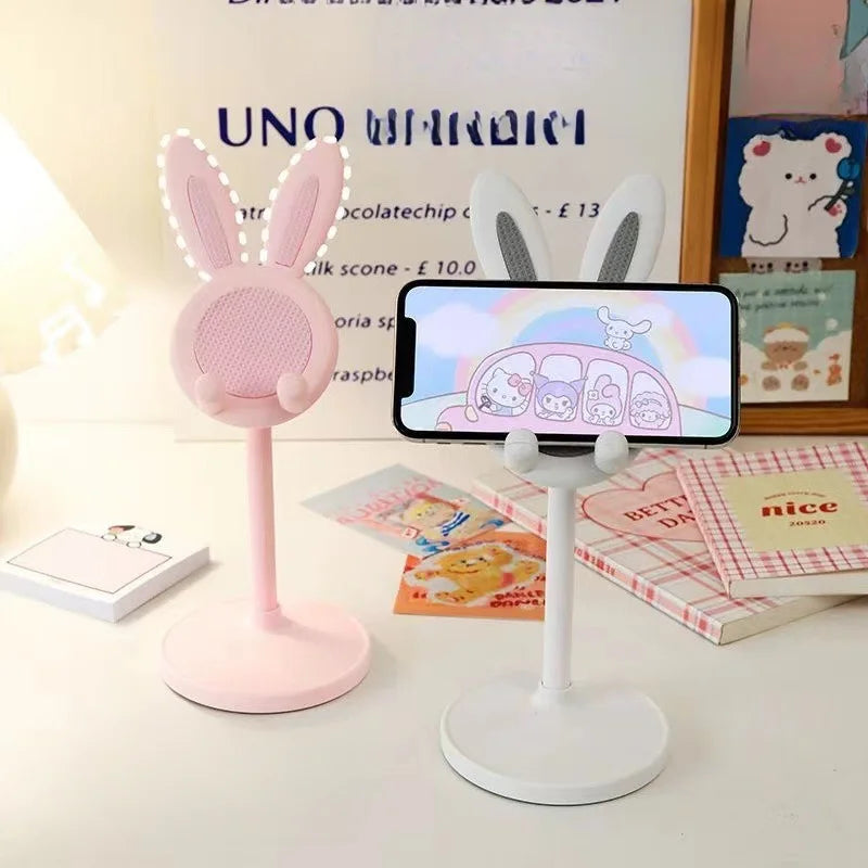 Pink and white rabbit phone stands on bases, each with a mounted smartphone