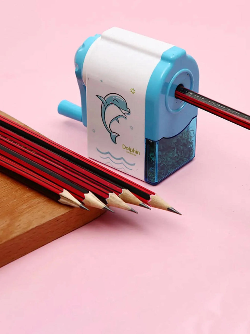 Blue dolphin pencil sharpener with crank handle and exposed pencil tips