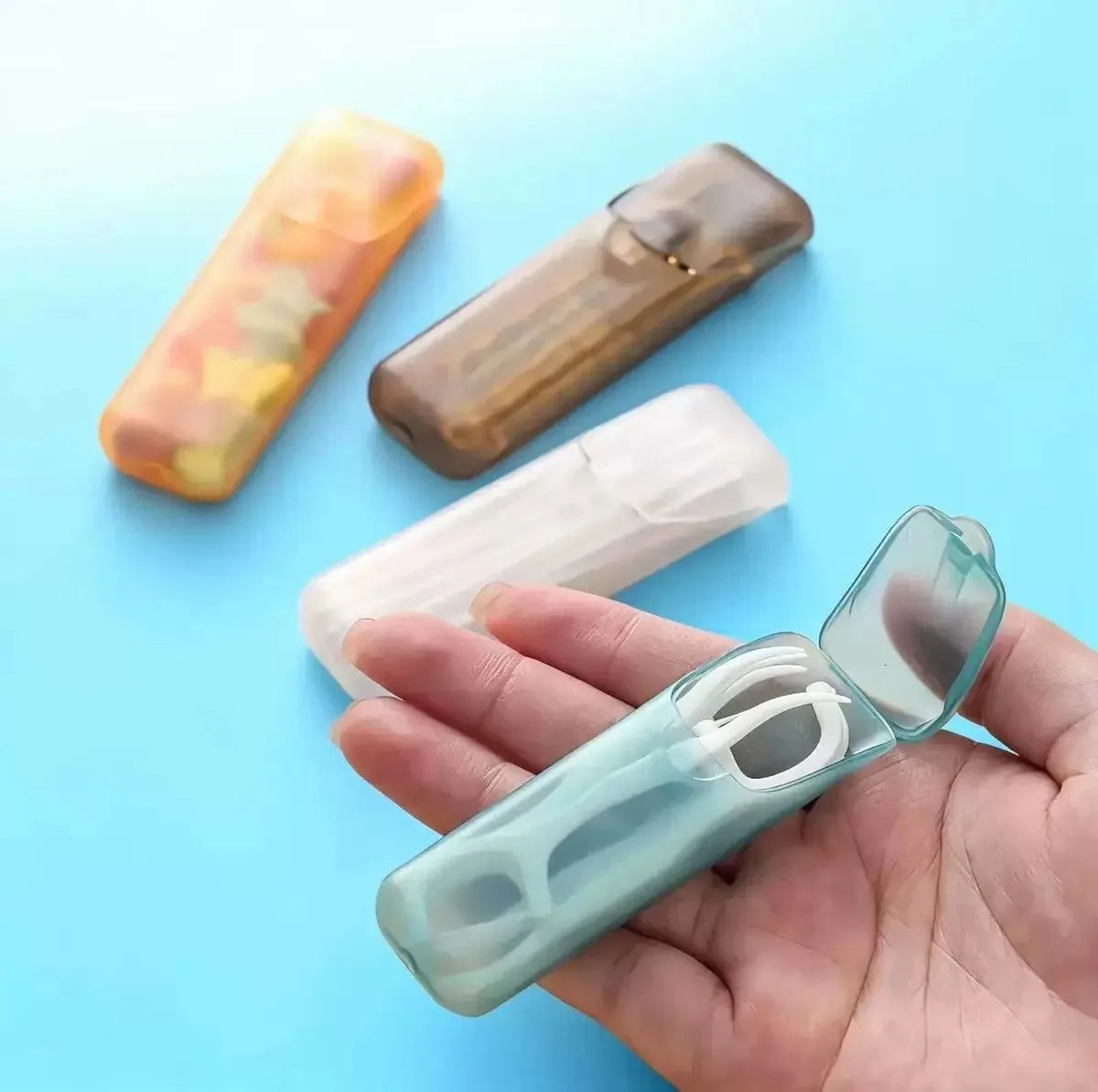 Mini portable storage box case in light blue, open lid visible while held in hand