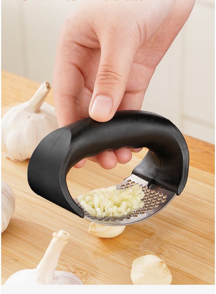 Manual garlic press held above garlic with perforated crushing plate