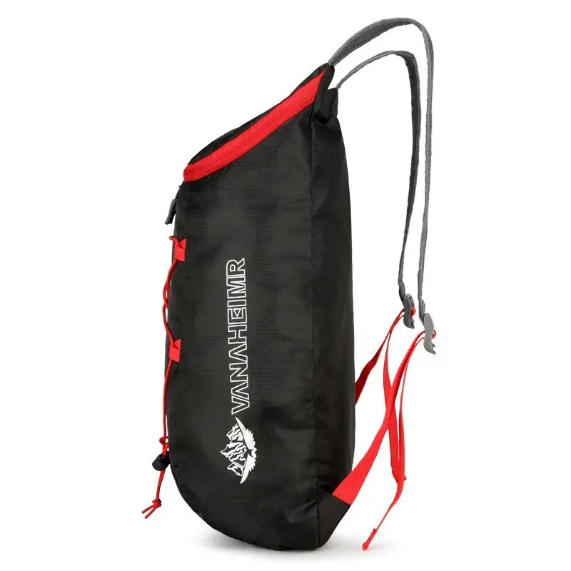 Black folding backpack with red trim, side carry straps, and mesh shoulder panel