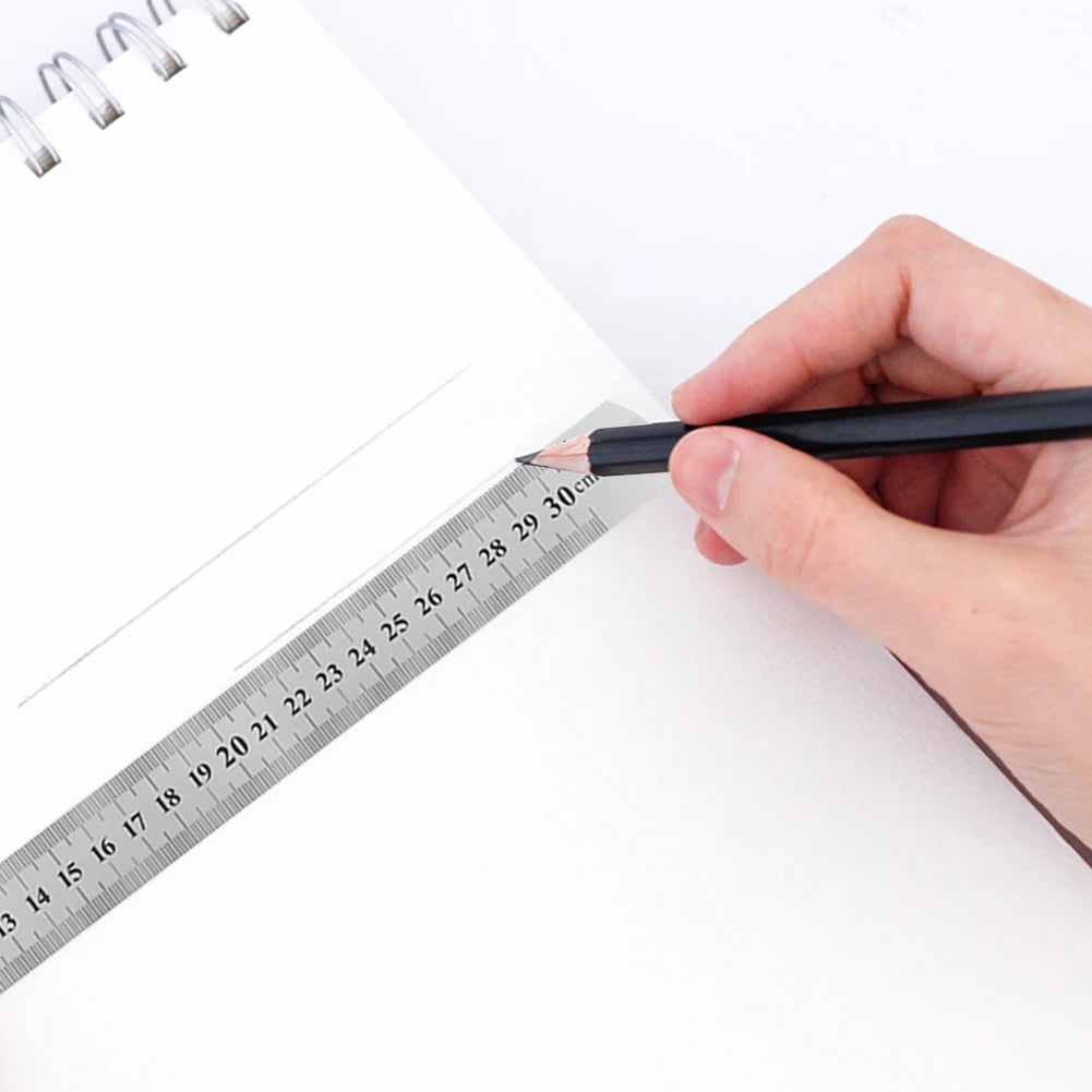 Stainless steel straight ruler with measurement scale held on paper for marking