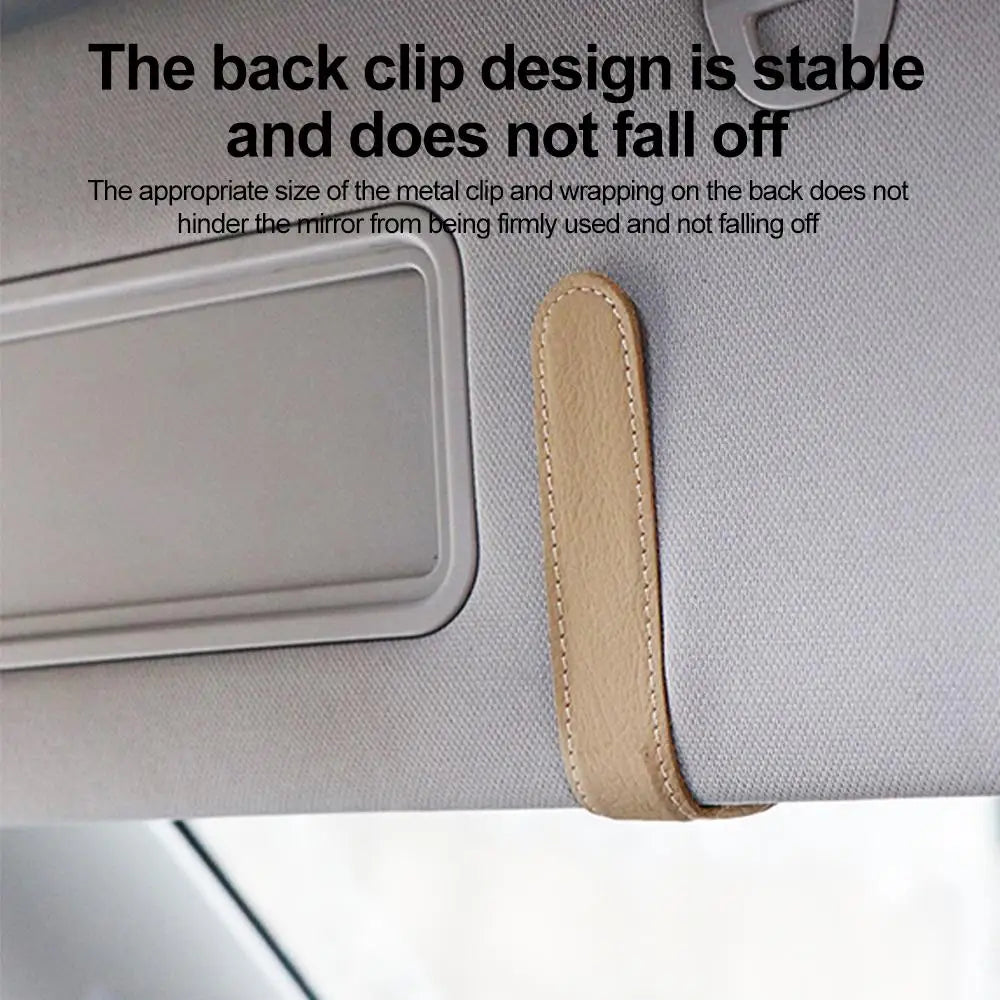 Beige car glasses clip holder with curved strap, attached clip, and stitched edges.