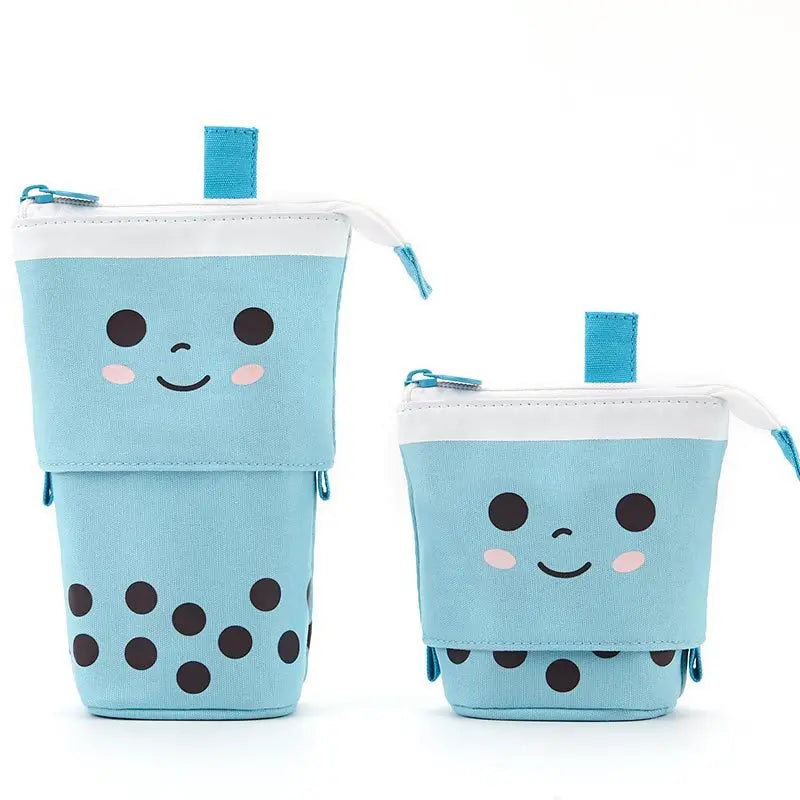 Two blue character pencil pouches with zipper, smiling face and dot details