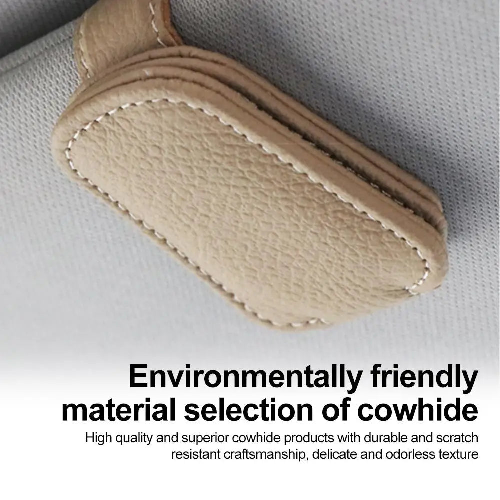 Beige car sunglasses clip holder close-up with visible stitched border and textured surface