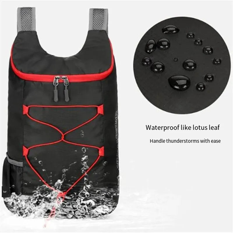 Black folding backpack with red piping, mesh straps, and water-splash fabric detail