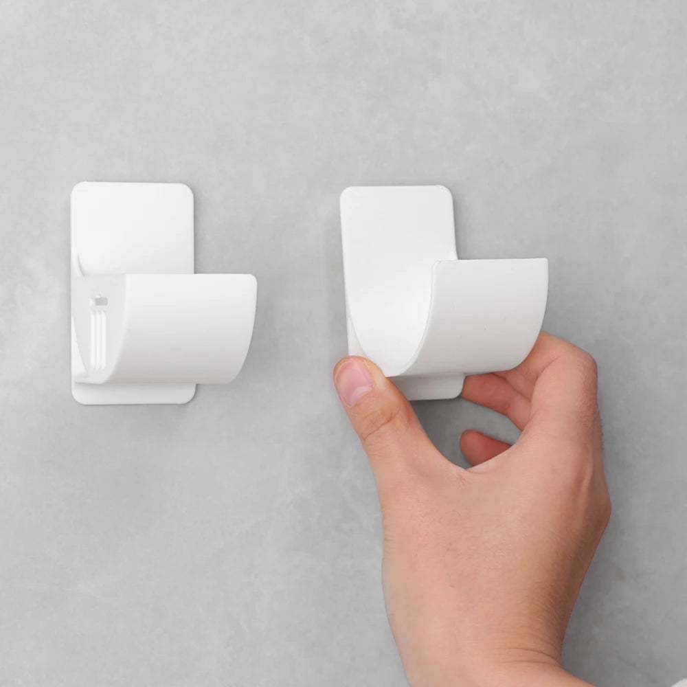 Set of two wall-mounted white trash bag holders with curved bag clips