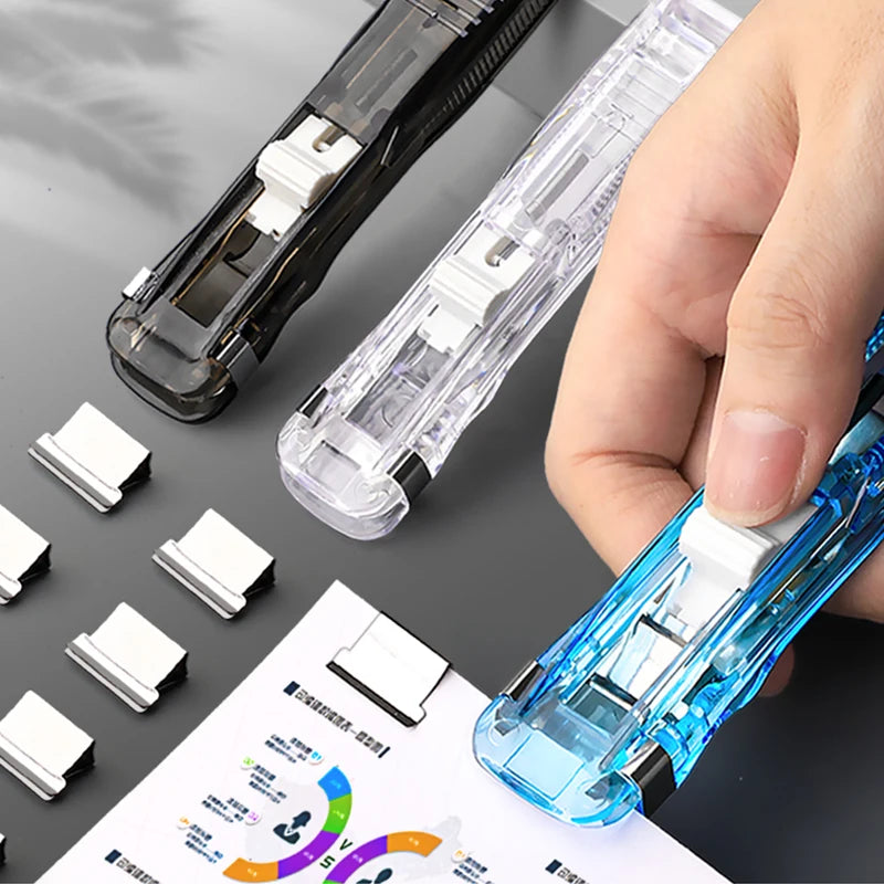 Clear push paper stapler clamp held by hand with white paper clipped