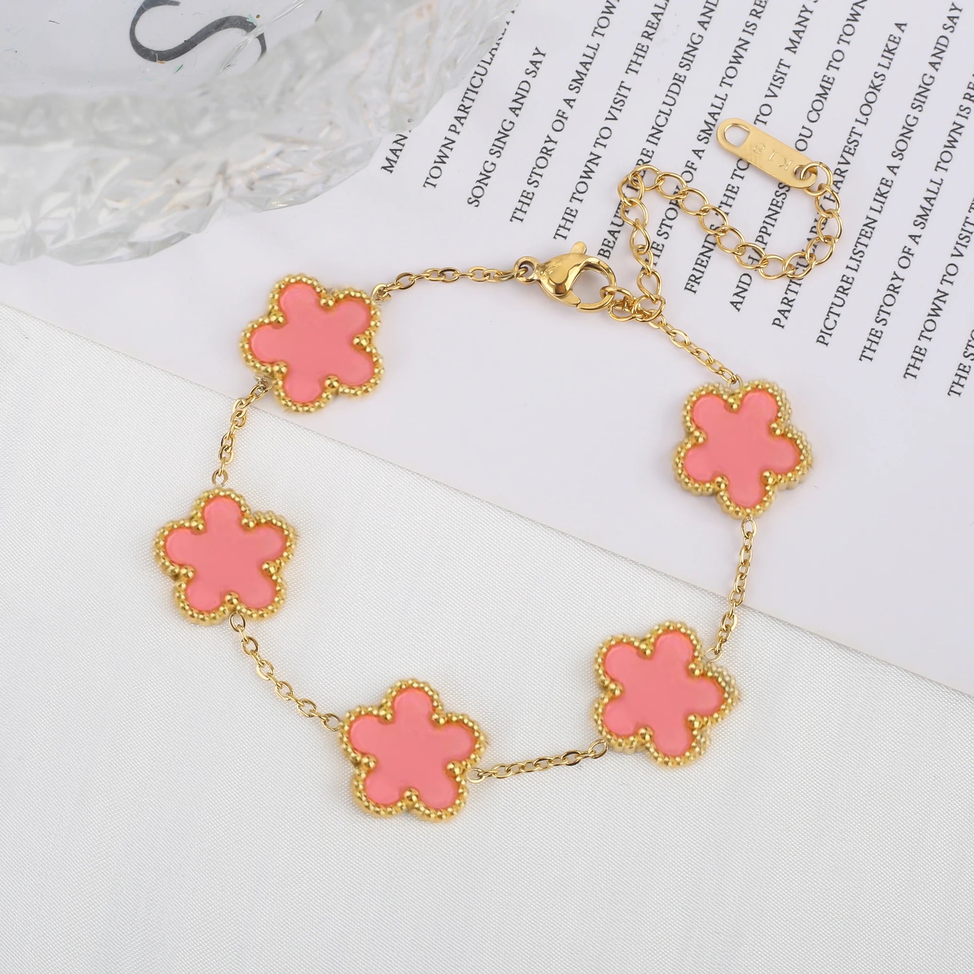 Adjustable gold-tone clover charm bracelet with pink enamel four-leaf pendants