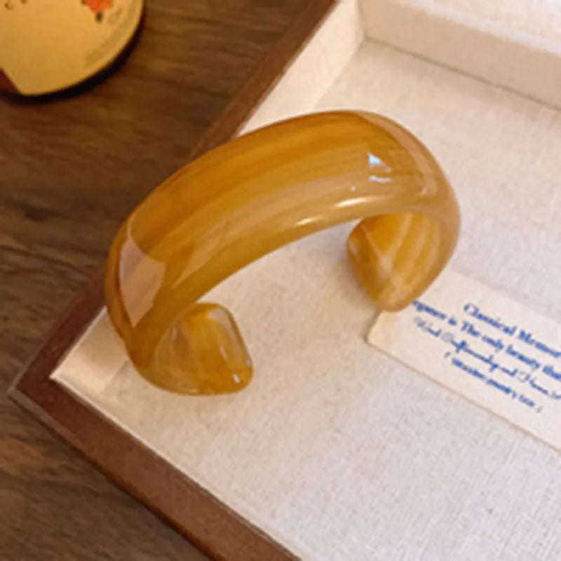 Amber translucent acrylic open bangle with shiny rounded face smudge design
