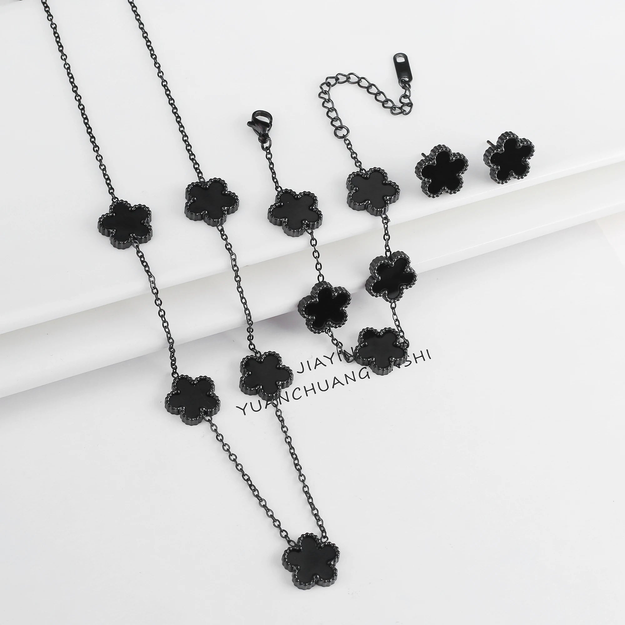 Black jewelry set with five-leaf flower necklaces, bracelet, and small drop earrings