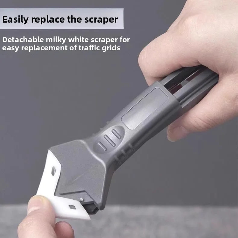 Multifunctional silicone scraper with detachable white blade insert and gray handle, held by hand