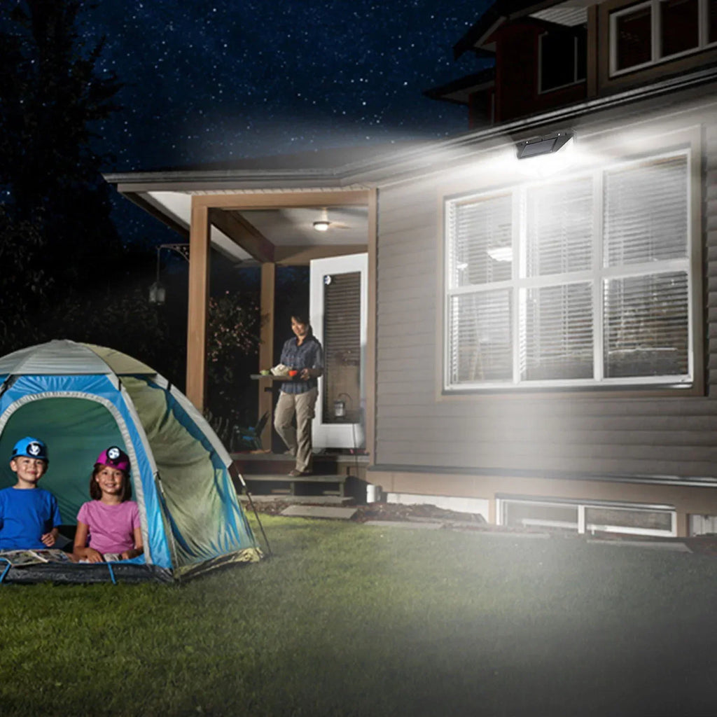Solar LED motion light glowing above patio entrance at night, black fixture
