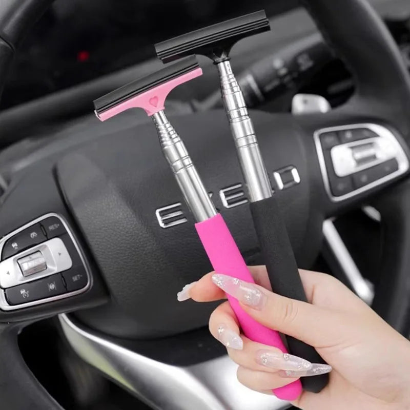 Pink and black telescopic car mirror wiper held in hand for cleaning