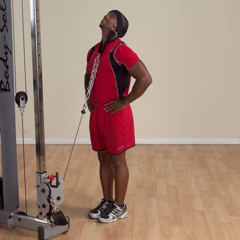 Neck training harness worn with steel chain weight while standing in a gym