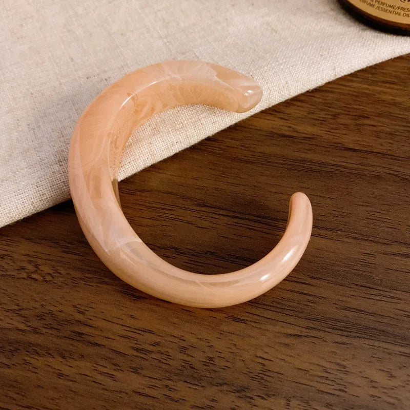 Light pink translucent glossy open acrylic bangle with wide smooth open cuff