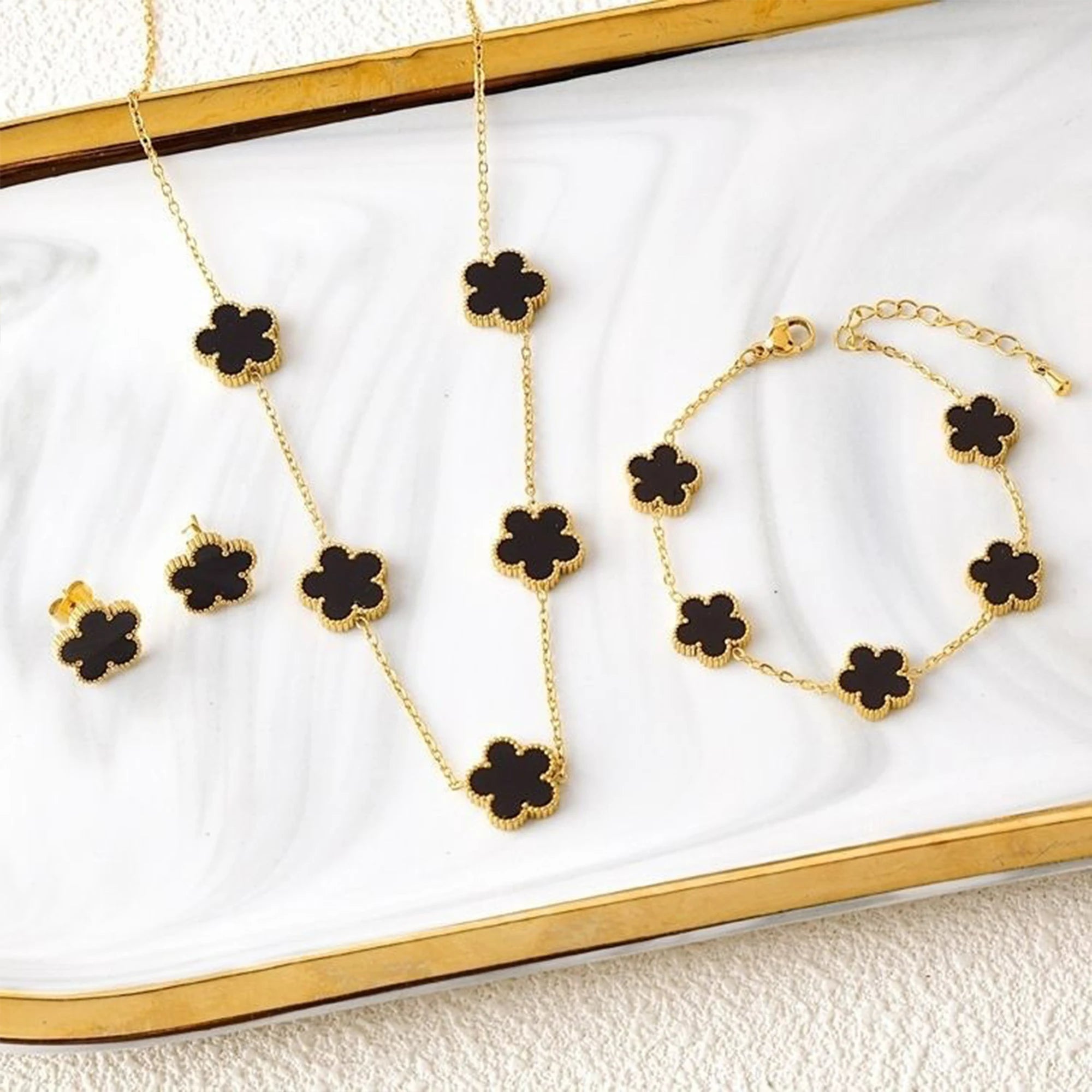 Gold-tone five-leaf flower charm jewelry set: necklace, bracelet, and stud earrings