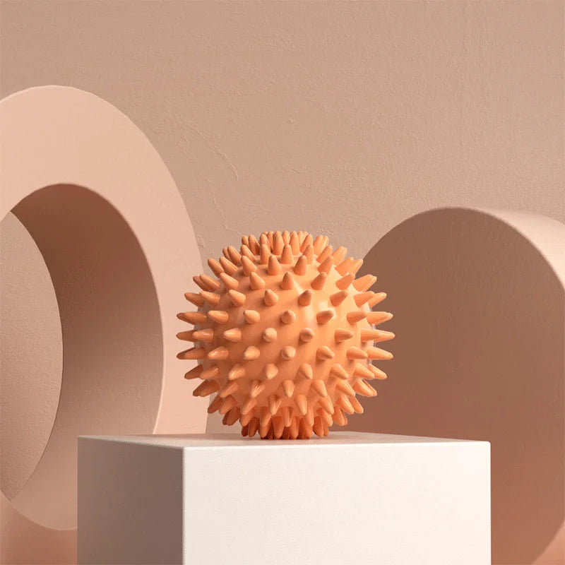 Orange spiky fascia massage ball on a pedestal