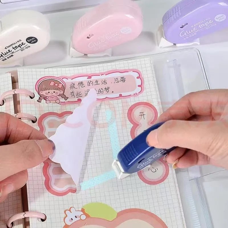 Blue double-sided adhesive tape dispenser applying adhesive dots to paper cutouts