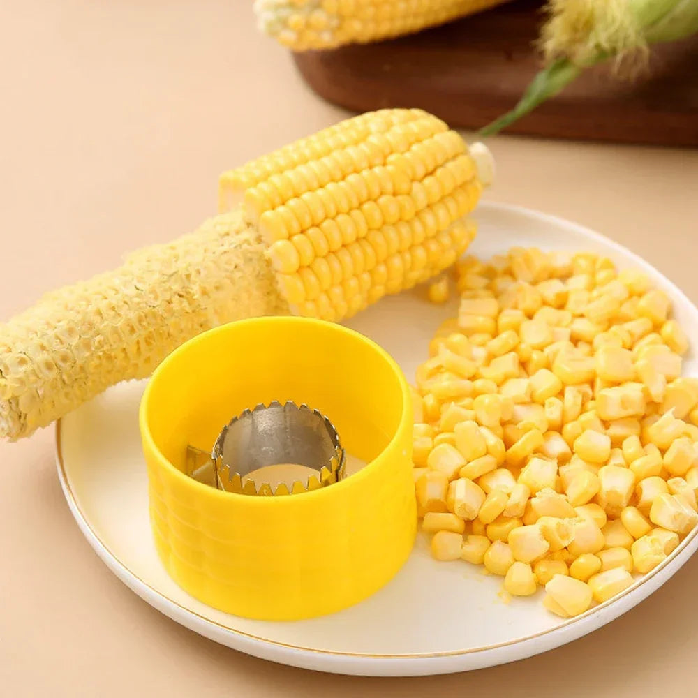 Yellow corn cob stripper peeler cup on a plate with serrated blade and corn kernels.