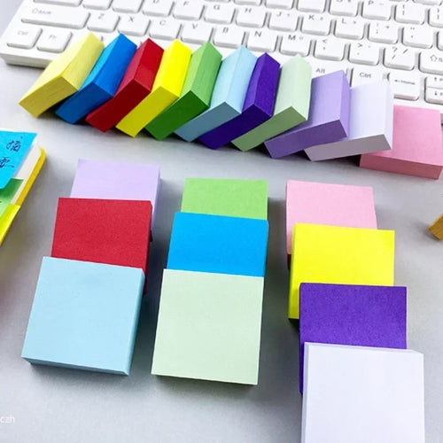 Fluorescent sticky note cubes in assorted colors, stacked with square memo pads.