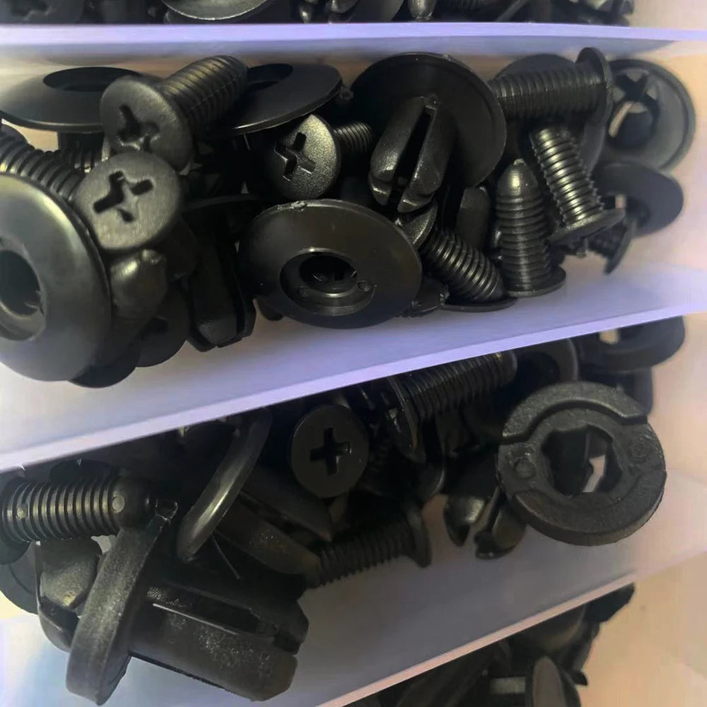 Close-up of mixed black push retainer clips with threaded stems and round caps