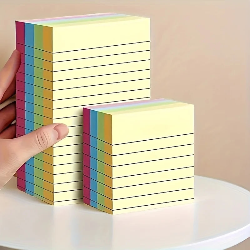 Two stacks of square sticky note pads in pastel rainbow stripe edges