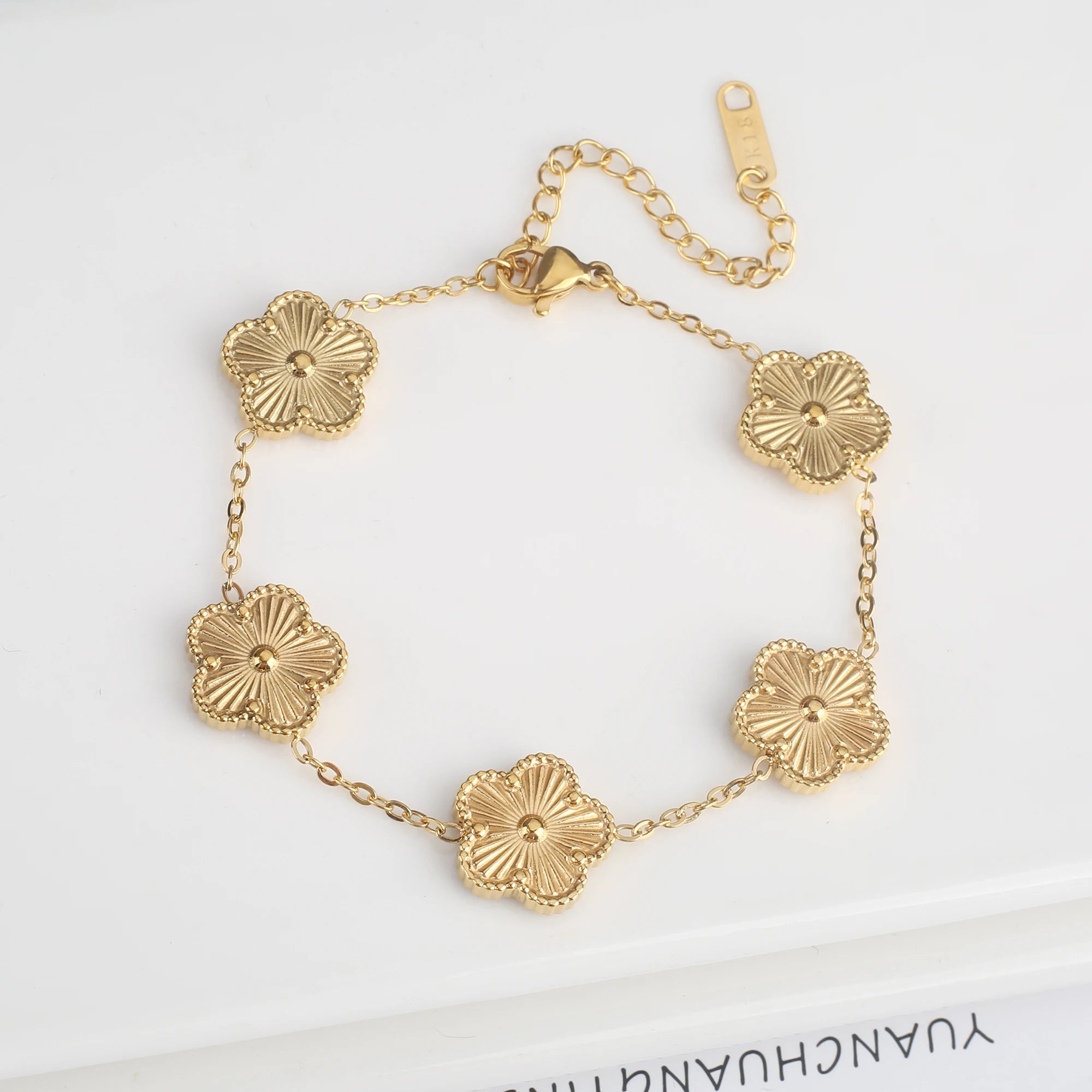 Adjustable gold bracelet with five scalloped flower medallion charms and chain
