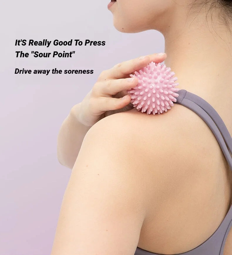 Pink spiky massage ball pressed to shoulder and neck area for point relief