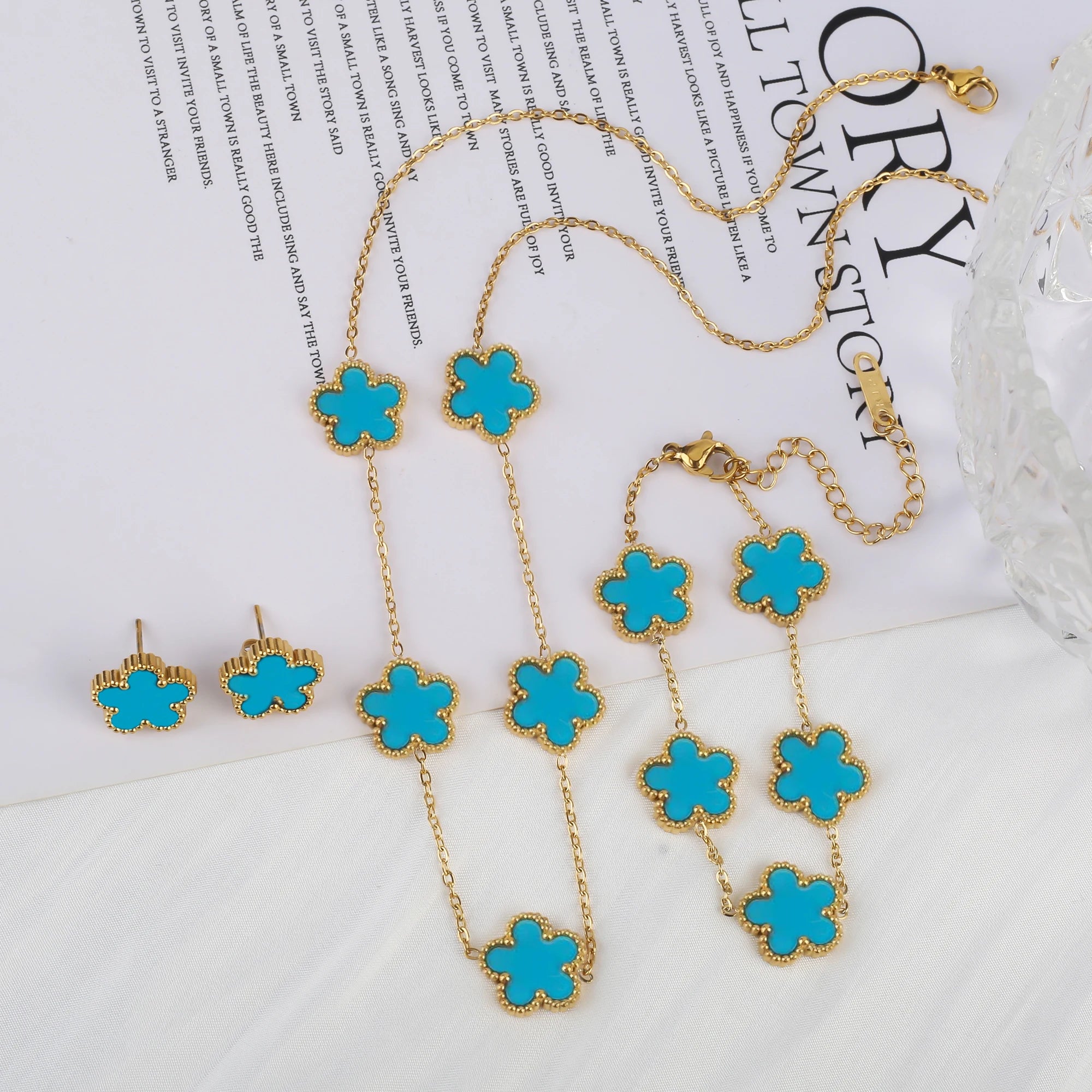 Gold-tone five-leaf flower charm jewelry set with turquoise pendants and chain links