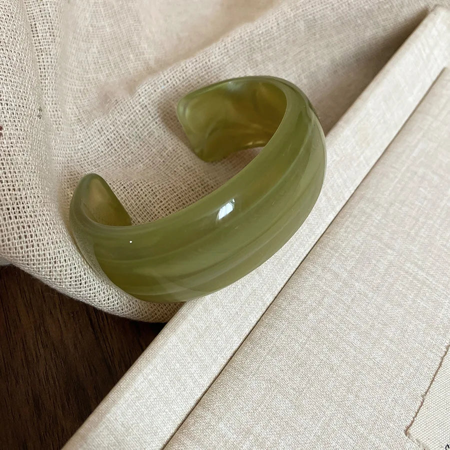Shiny acrylic open bangle in olive green, wide curved bracelet with glossy finish