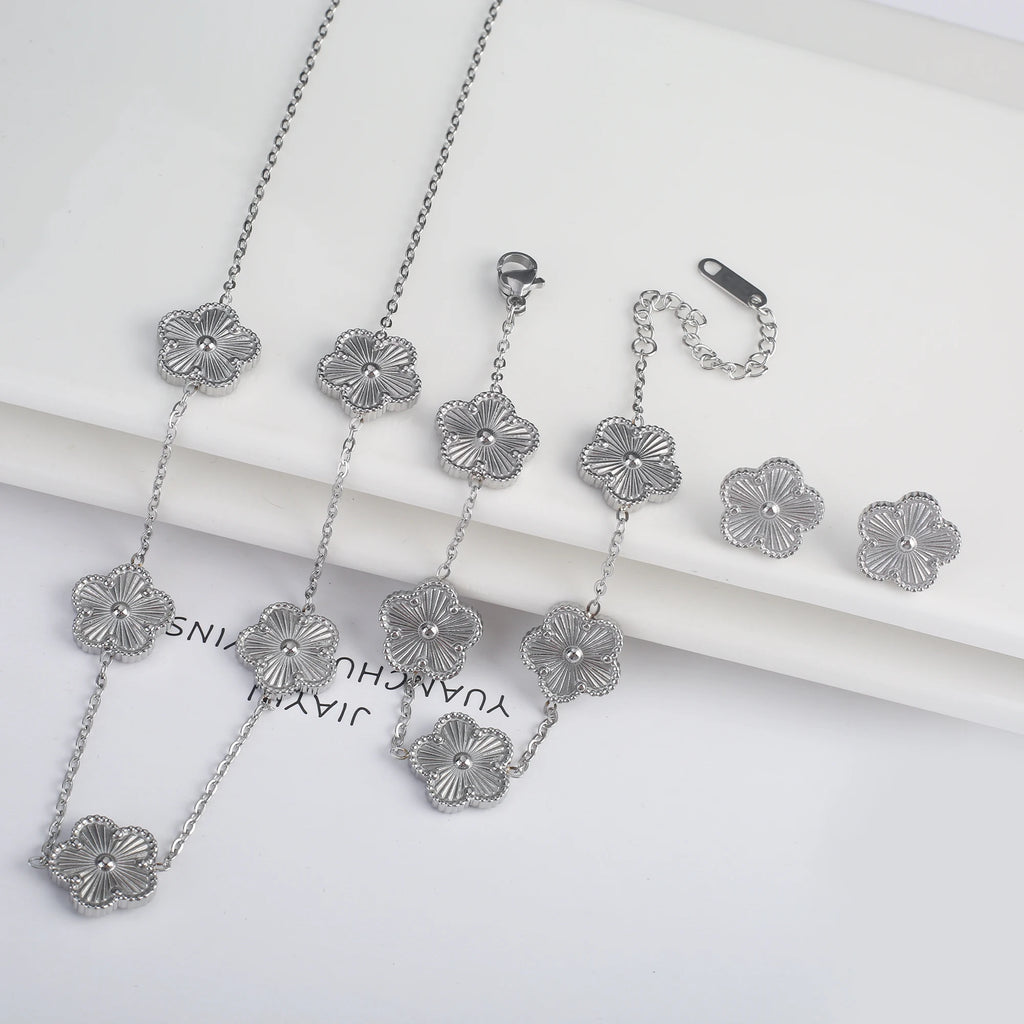Three-piece clover jewelry set with five-leaf flower charms, silver tone necklaces and dangling earrings