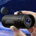 Black compact monocular telescope with large objective lens and red ring, held in hand