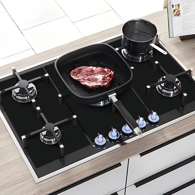 Gas cooktop with black stove protector pads covering burner areas