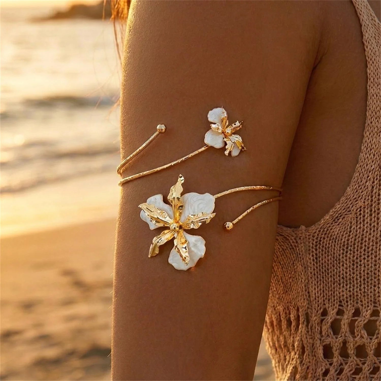 Gold open cuff arm bracelet with three white enamel flowers and small bead accents